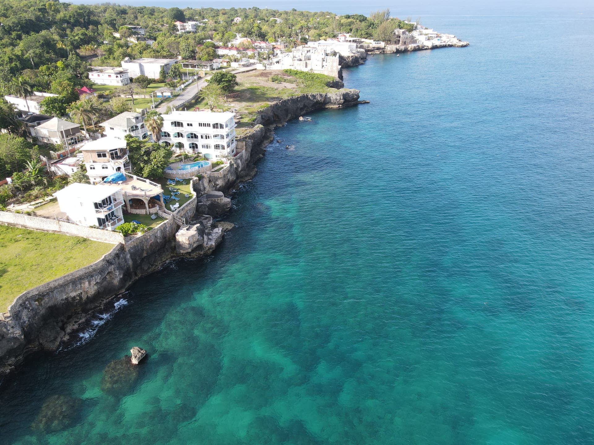 Aerial view of Home Sweet Home Resort's cliffs, sea stairs, and the reef below