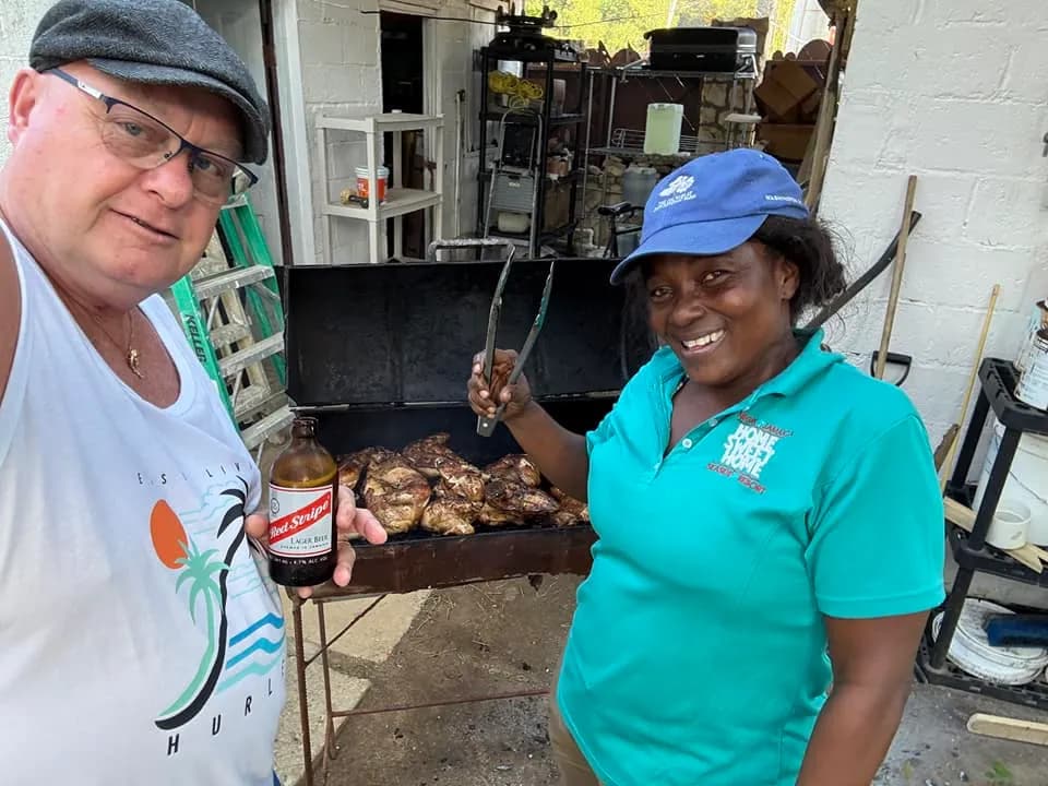 A guest with our chef at the jerk grill