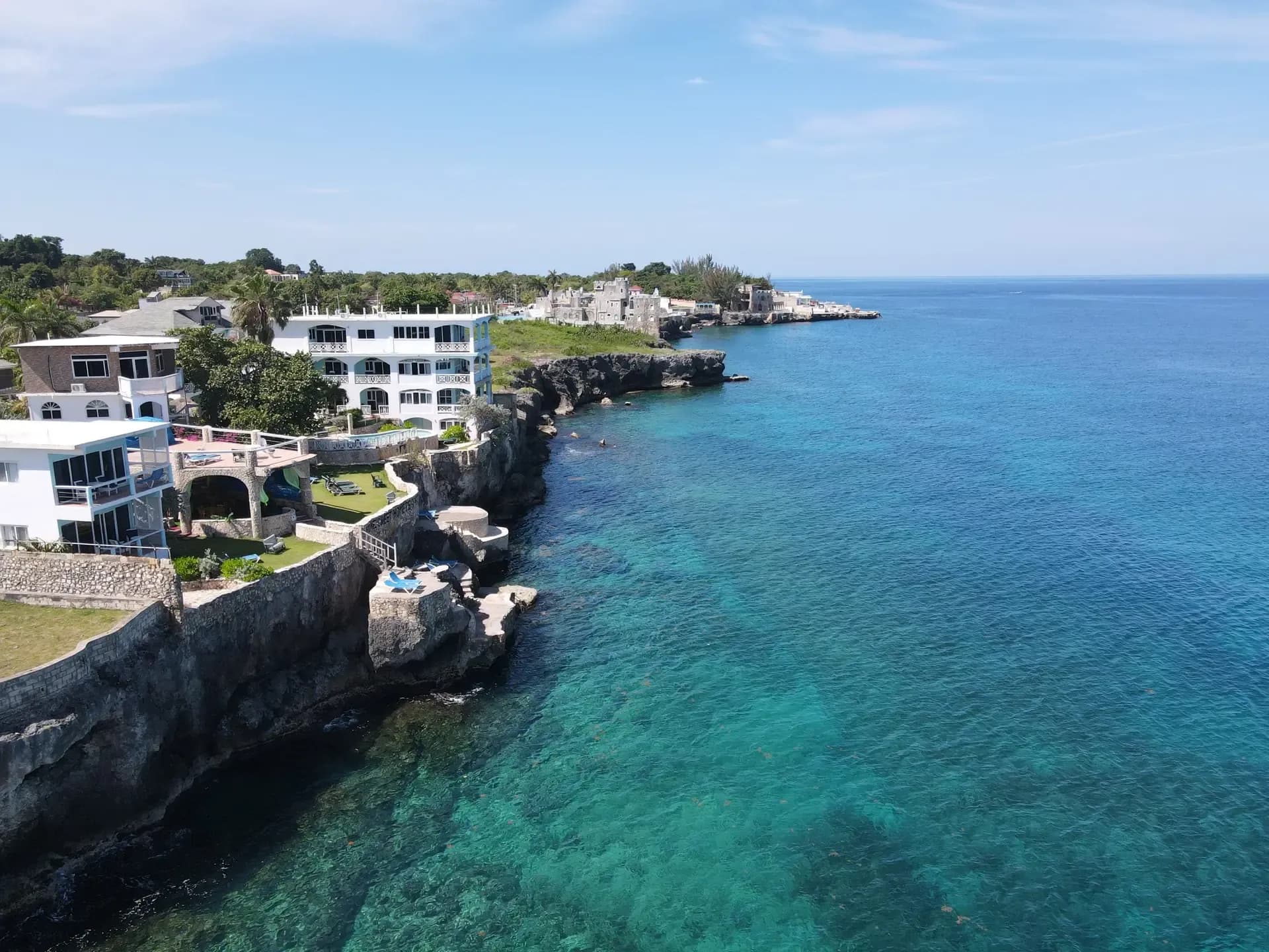 Aerial view of Home Sweet Home Resort on the West End cliffs, with the reef and the coastline beyond