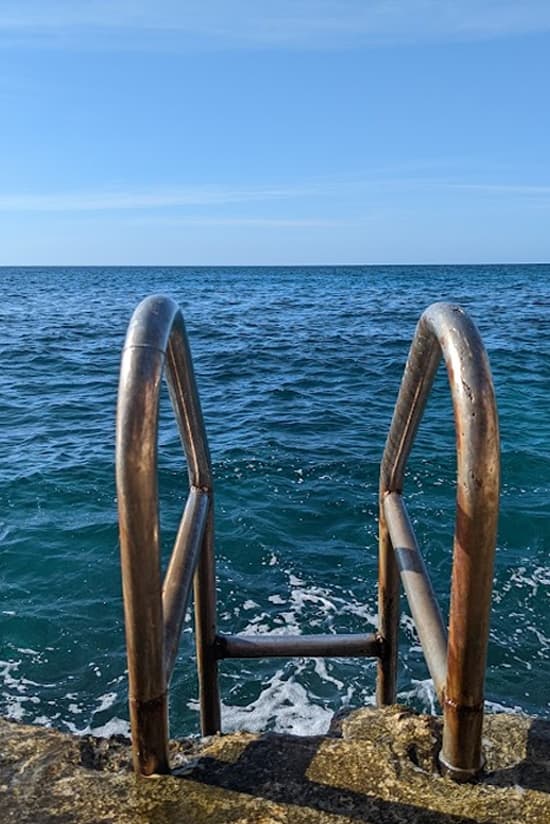 Ladder into the clear Caribbean Sea below the cliffs at Home Sweet Home Resort