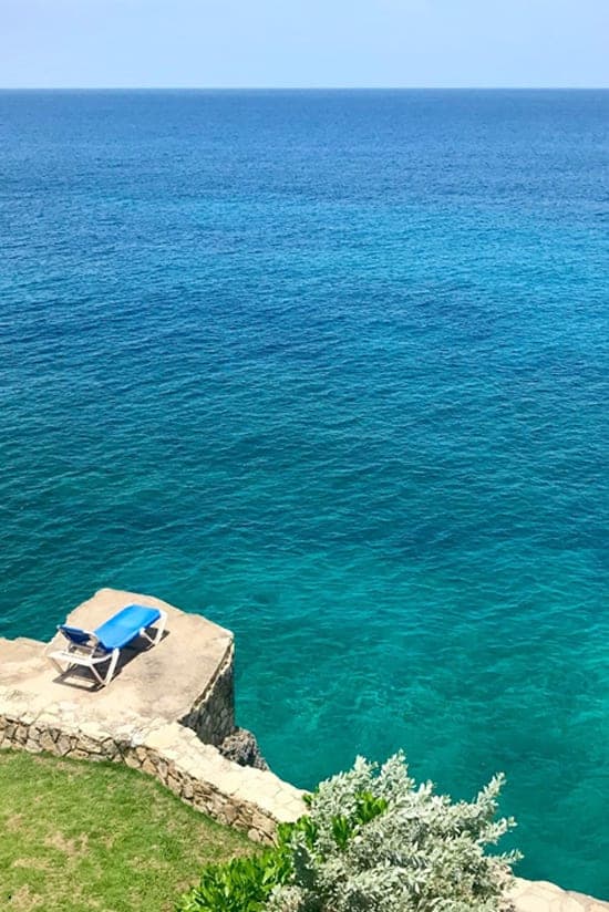 Lounger perched above the turquoise sea at Home Sweet Home Resort
