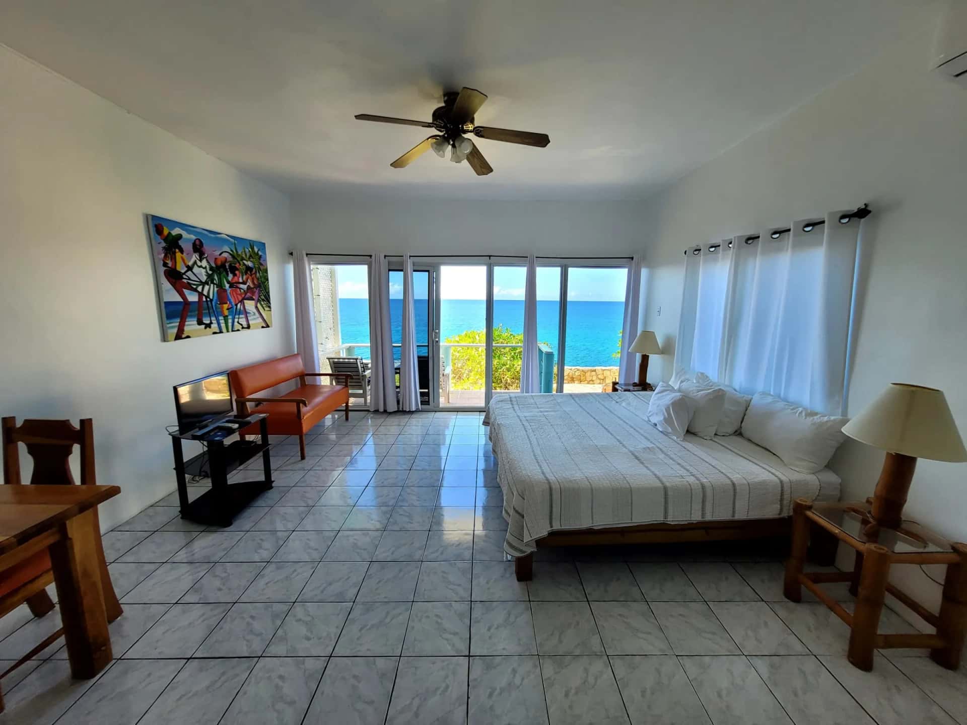King bed in the open Cliffedge Suite with sliding doors opening to the sea-view balcony, Room 15