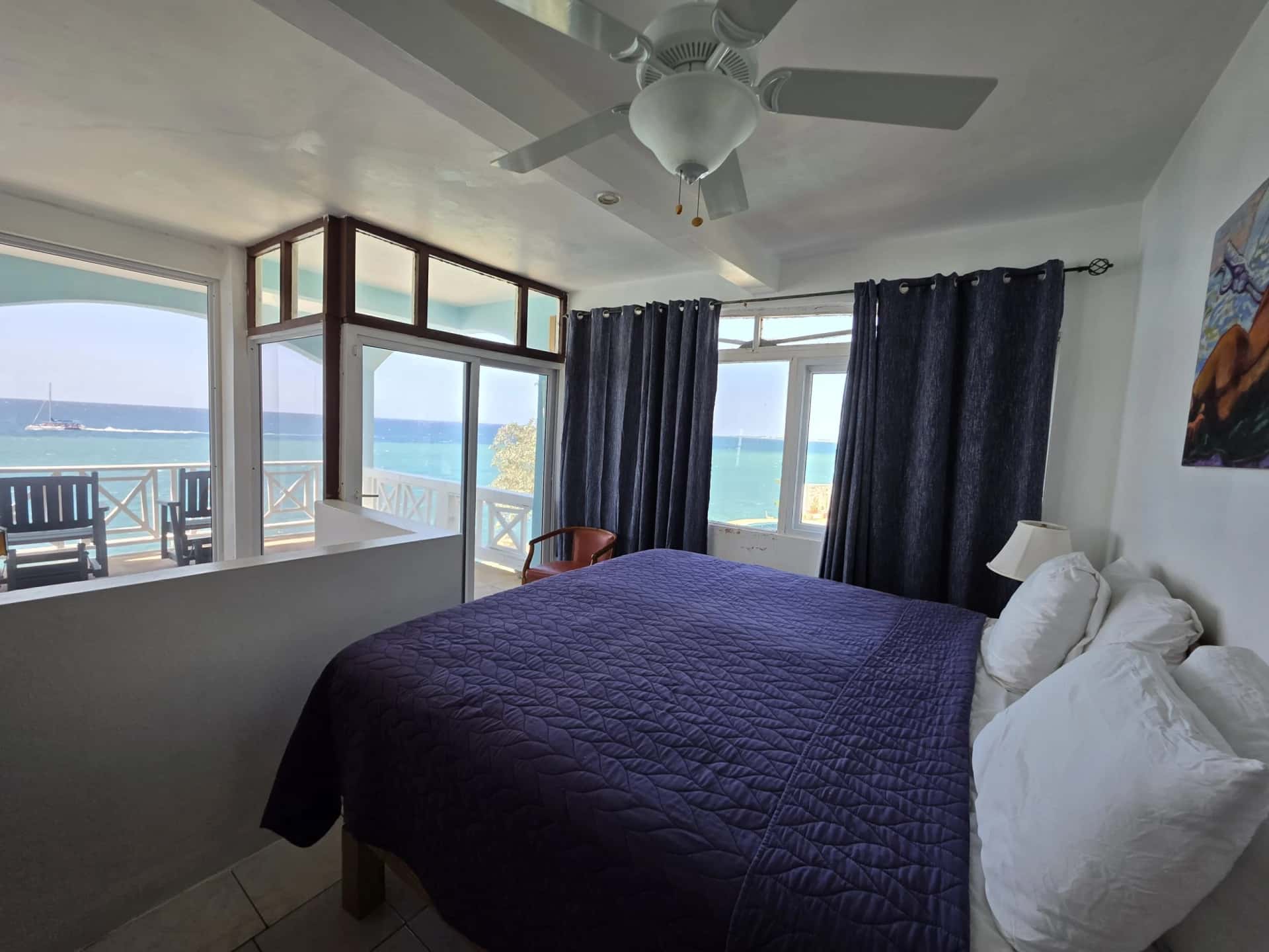 King bed with sea-view windows and a private balcony in the Executive Suite, Room 11
