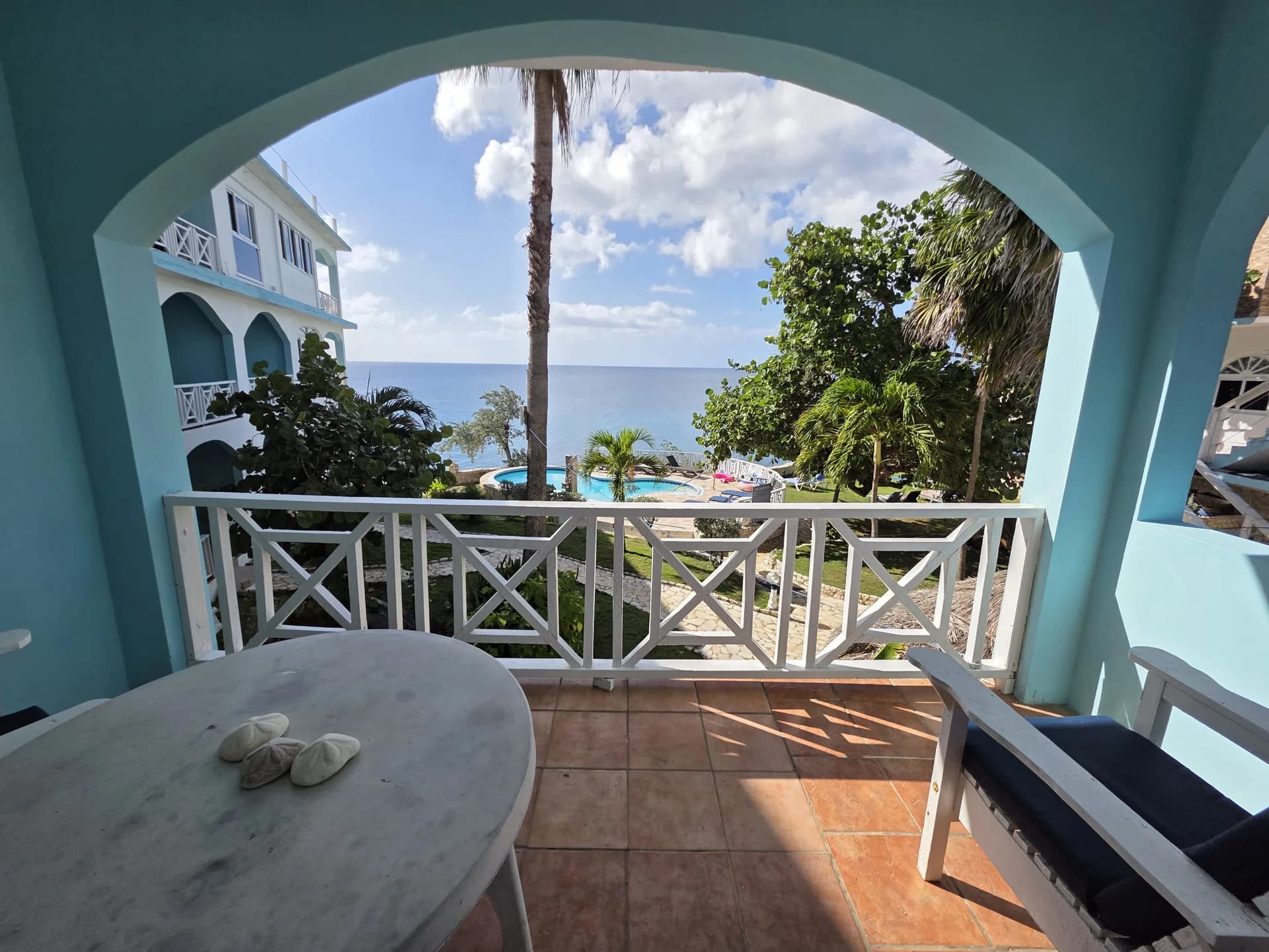 Private balcony with a table overlooking the Caribbean Sea at Seaview Deluxe Room 2
