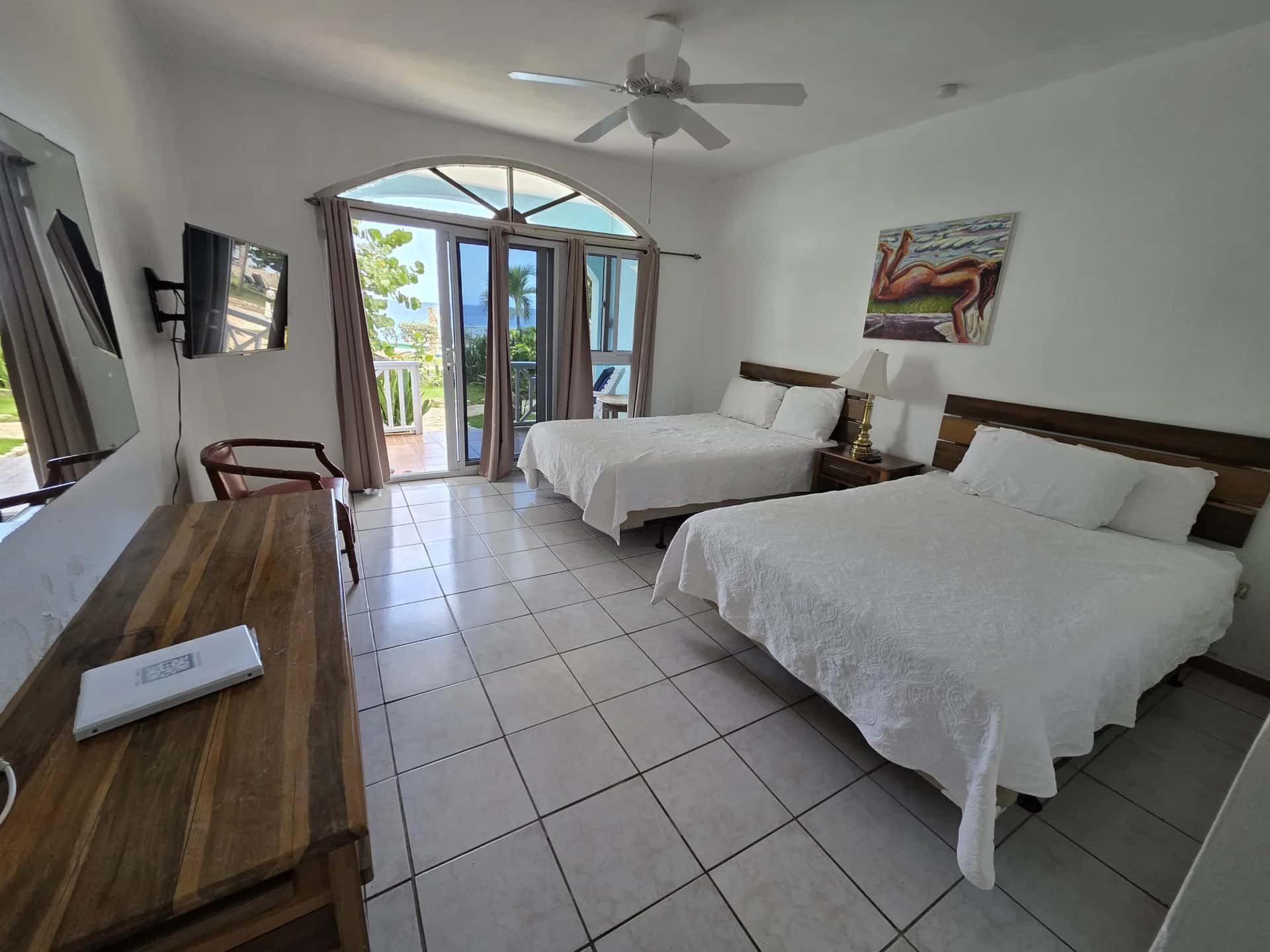Two double beds with balcony doors and sea views in Seaview Deluxe Room 3