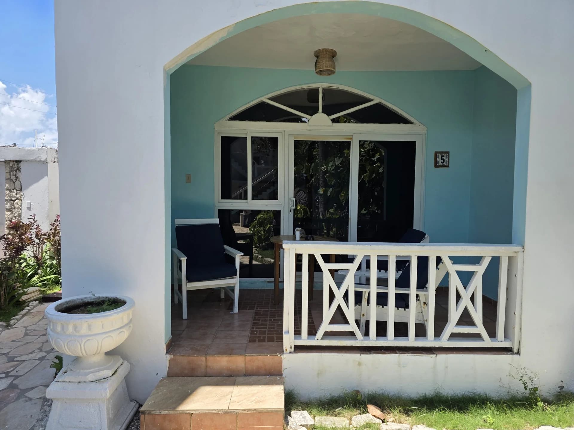 Private terrace and tropical grounds beside Seaview Deluxe King Room 5 at Home Sweet Home Resort