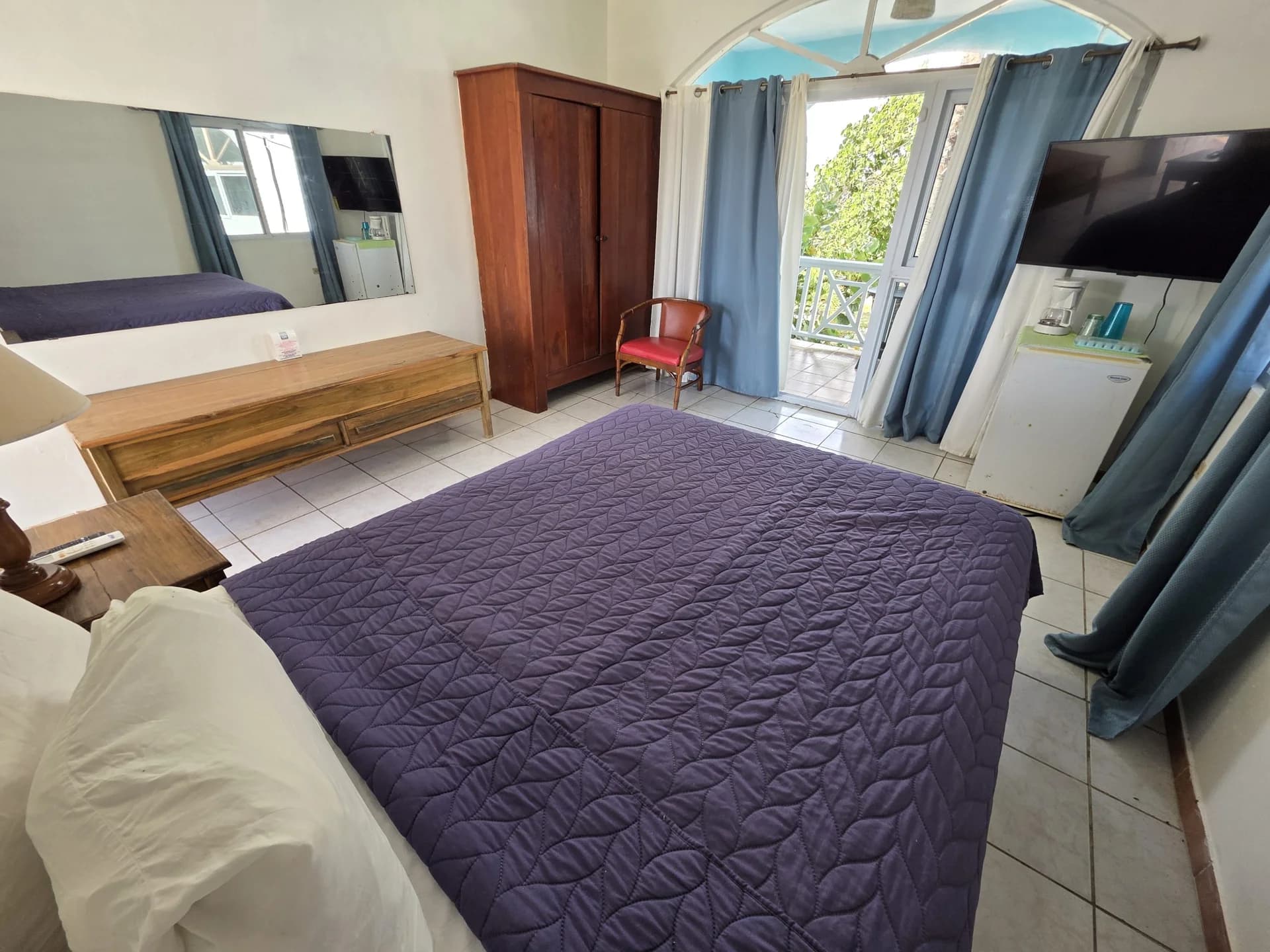 Queen bed with sea-view balcony doors in Seaview Deluxe Queen Room 6