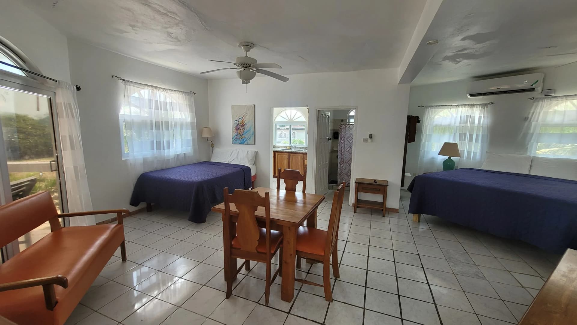 Spacious Seaview Suite with a king bed, a dining table and white tile floors in Room 13