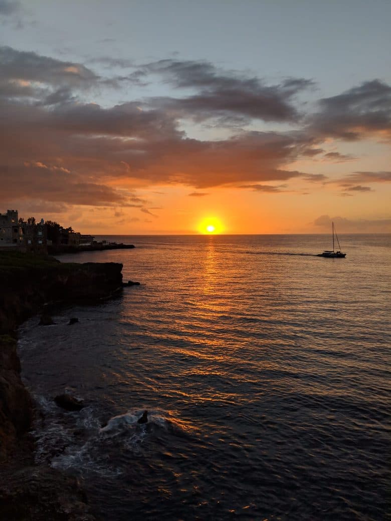 Sailboat crossing the sunset off Negril's West End cliffs