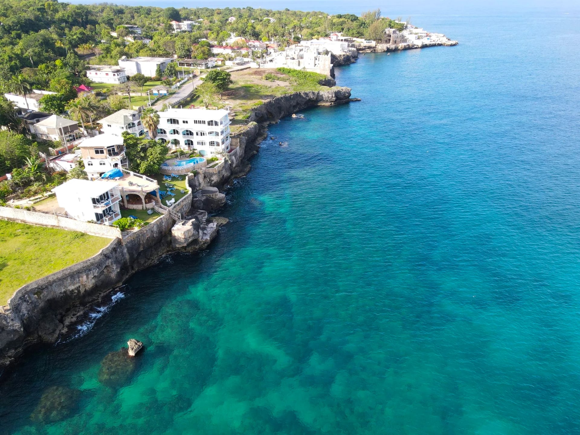 Aerial view of Home Sweet Home Resort's cliffs, sea stairs, and the reef below